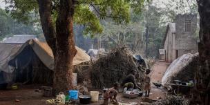 Yvonne and her two daughters prepare a meal next to their home on the Cesacoba site near Bangassou, Central African Republic, 2021. Adrienne Surprenant/ Oxfam Yvonne and her two daughters prepare a meal next to their home on the Cesacoba site near Bangassou, Central African Republic, 2021. Adrienne Surprenant/ Oxfam
