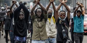 Demonstrators make signs with their arms in front of Kenyan police officers during a demonstration against tax hikes as Members of the Parliament debate the Finance Bill 2024 in downtown Nairobi, on June 18, 2024. The police fired tear gas and arrested dozens of demonstrators. Photo: Luis Tato/AFP via Getty Images