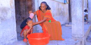 Ms. Birey Yohans Werede washes her daughter’s hair outside their shelter in Asgede Woreda, Tigray.