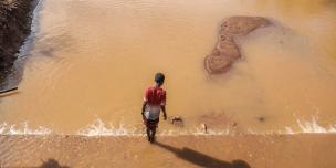 A child walking beside a destroyed bridge in Buna because of the floods. Photo credit: Mark Wahwai/ Oxfam A child walking beside a destroyed bridge in Buna because of the floods. Photo credit: Mark Wahwai/ Oxfam