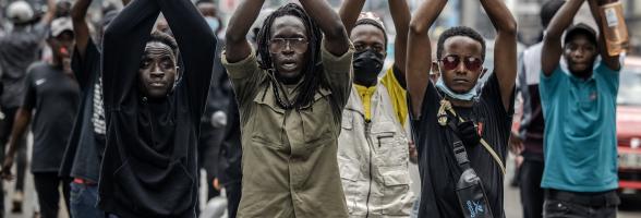 Demonstrators make signs with their arms in front of Kenyan police officers during a demonstration against tax hikes as Members of the Parliament debate the Finance Bill 2024 in downtown Nairobi, on June 18, 2024. The police fired tear gas and arrested dozens of demonstrators. Photo: Luis Tato/AFP via Getty Images