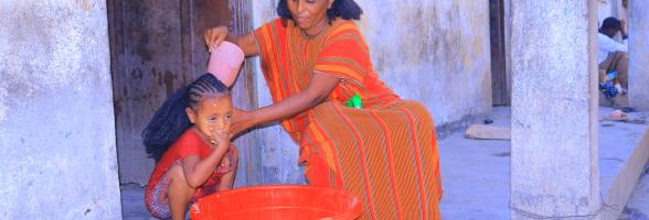 Ms. Birey Yohans Werede washes her daughter’s hair outside their shelter in Asgede Woreda, Tigray.