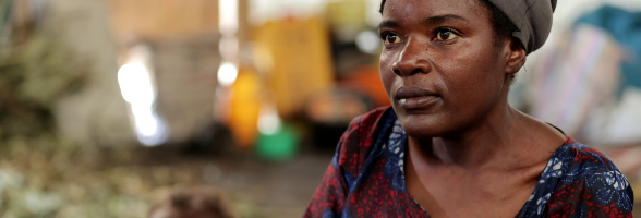 Feza Damani, mother of seven, fled the village of Kiwanja in the Rutshuru region. She has been living in Rusayo since September 2023. Mrs Feza and her seven children now live in a communal warehouse with several other displaced people. Photo credit: Yves Kalwira/ Oxfam