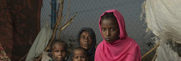 Asia*, a young refugee girl who fled the war in Sudan, sits outside her makeshift home in Renk. Credit: Peter Caton/Oxfam