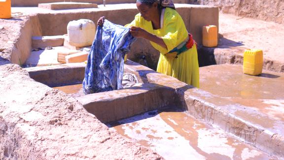 Feleg G/mariam washes clothes at Meshano spring water point in Birhan kebelle,Tigray, Ethiopia, after the spring was rehabilitated.