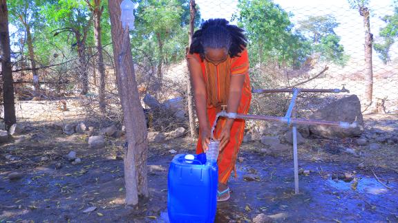 Ms. Birey Yohans Werede, 40, fills a jerrycan at a water point near her shelter in Hitsats, Tigray.
