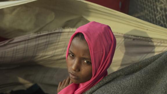 Asia*, a young refugee girl who fled the war in Sudan, sits outside her makeshift home in Renk. Credit: Peter Caton/Oxfam