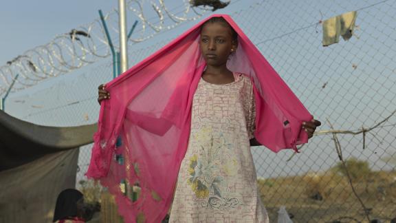 Asia*, a young refugee girl who fled the war in Sudan, sits outside her makeshift home in Renk. Credit: Peter Caton/Oxfam
