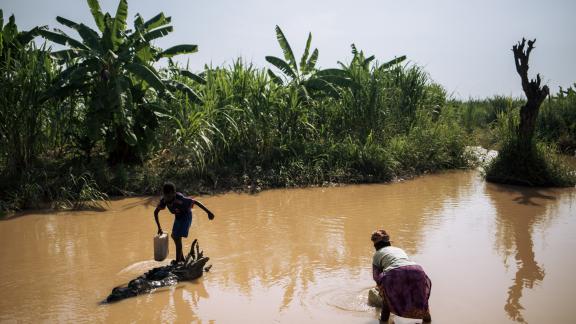 Femme et garçon recueillant de l'eau dans une rivière sale -Malinde. Photo Alexis Huguet/Oxfam Femme et garçon recueillant de l'eau dans une rivière sale -Malinde. Photo Alexis Huguet/Oxfam