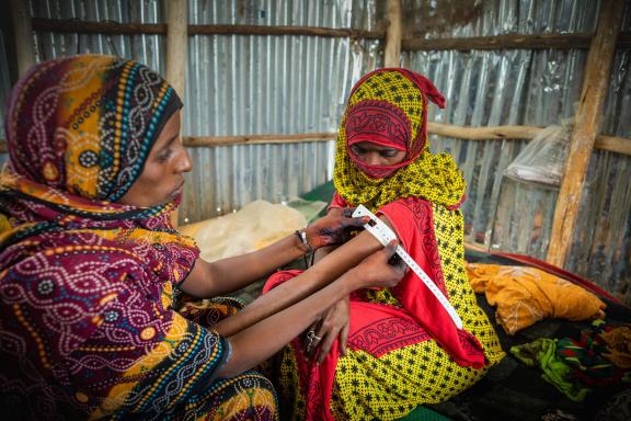 Zahara Kalayta Omar is a health extension worker trained by the Afar Pastoralist Development Association. She is demonstrating how to measure the mid-upper arm circumference on her neighbor Fatuma Adagere Mohamed.