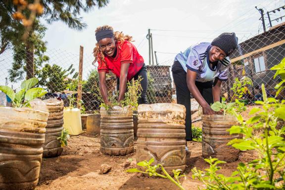 Member of CIVACT Youth group- Nabatanzi Stella and Zuwena Khalil weed the pop up gardens at the group demonstration garden in Kitintale, Kampala.