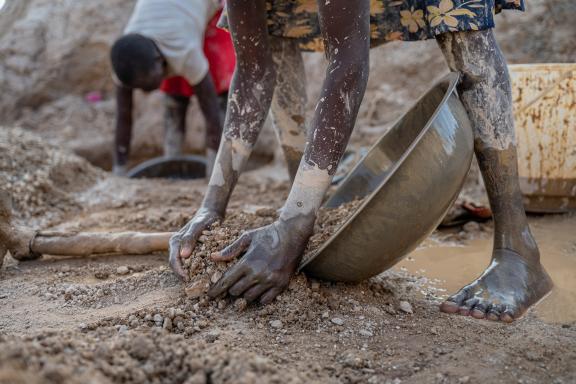 Gold mine rock is put on a metal tray for washing. in Turkana county, Kenya.