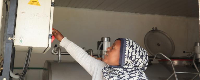 Berehane Eshete, 36, a mother of three and manager of the Andenet (Cheki Andinet) Dairy Cooperative Association in Debre Birhan, switches on the milk chiller to keep fresh deliveries cool and safe. Photo: Liban Hailu/Oxfam