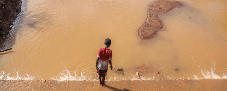 A child walking beside a destroyed bridge in Buna because of the floods. Photo credit: Mark Wahwai/ Oxfam