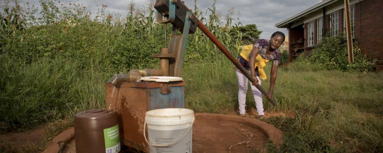 Abigail cleans her bucket before preparing to draw water from a borehole near her home in Hatcliffe, Harare, Zimbabwe. CREDIT Cynthia Matonhodze/Oxfam