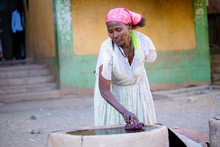 50 year old Hareyat Gebrelibanos and a mother of four from Tigray in Northern Ethiopia cleaning mitad* traditional griddle used for cooking bread at Meles IDP camp. Photo Credit: Zerubabel Tore/Oxfam