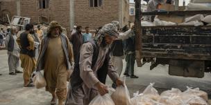 Volunteers help unload food packages at an Oxfam food distribution site in Herat, 2020. Photo: Kiana Hayeri