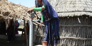 woman from Pakistan using a hand pump woman from Pakistan using a hand pump