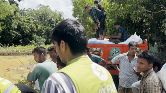 Trinagdi, alongside Oxfam's aid team, helps distribute essential supplies to flood-affected communities in Bangladesh, showcasing the power of youth volunteerism.
