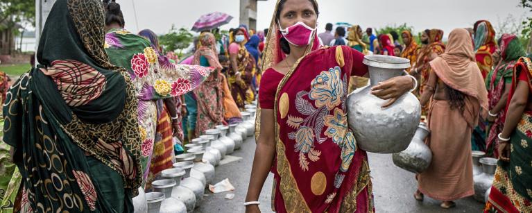 Women gathering water after cyclone amphan