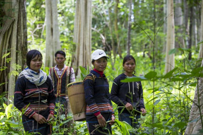 Sav Leat stands behind the young women in the community forest of Pa Tang village while they are posting for a picture to share on their facebook. Photo by Savann Oeurm/Oxfam Sav Leat stands behind the young women in the community forest of Pa Tang village while they are posting for a picture to share on their facebook. Photo by Savann Oeurm/Oxfam