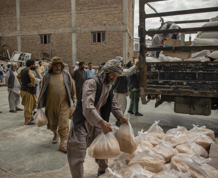 Volunteers help unload food packages at an Oxfam food distribution site in Herat, 2020. Photo: Kiana Hayeri