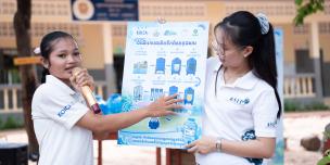 Ms. Poern Sreyleak (left), the Varin Water Kiosk Operator, explains the 10-step water treatment process, emphasizing its proven safety and quality standards, as verified by the Pasteur Institute of Cambodia. Photo: Oxfam