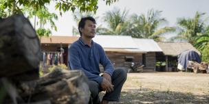 A month home, Ratana surveys the fragile yard that holds the cart, the chickens, and memories of months that changed everything