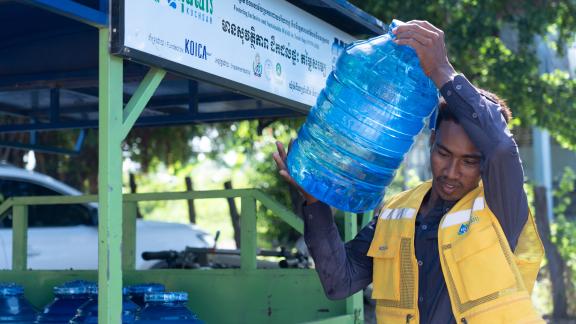A water kiosk operator prepared 20 liter bottles of Kuchsar water, providing reliable and safe drinking water to rural communities. Photo: Oxfam