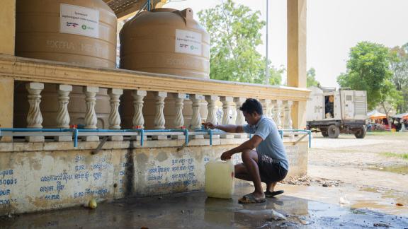 Mr. Ra Vin collecting water from the water filtration system at Wat Chan Sii safety centre, a daily journey families made before clean water points were installed at the camp. Photo: Oxfam