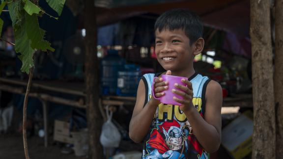 Nang's grandchild enjoying a refreshing cup of clean water from the new filtration system. 
