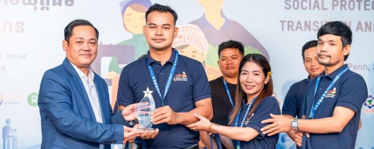 The first winning group, Ms. Pisey Som, Mr. Touch Pov, Mr. Chantha Mok, received their award during the award reception presented by H.E.Dr. Sophannarith Heng, Deputy Director General of the National Social Security Fund, Ministry of Labour and Vocational Training. Photo: Oxfam