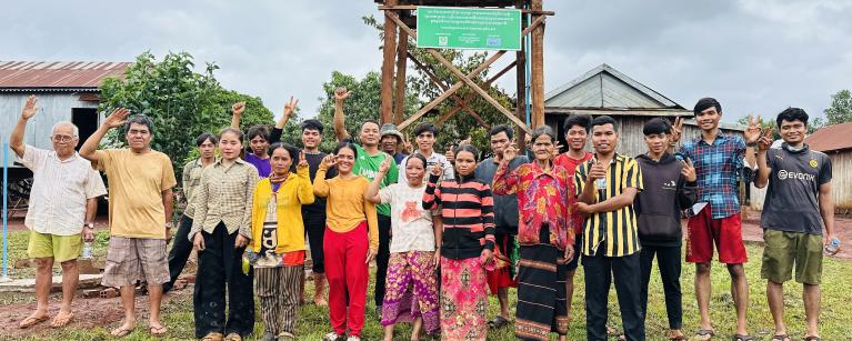 Members of the local community proudly gather in front of the newly installed  solar-powered water pump, made possible through the project’s dedication to  clean energy and safe water access.
