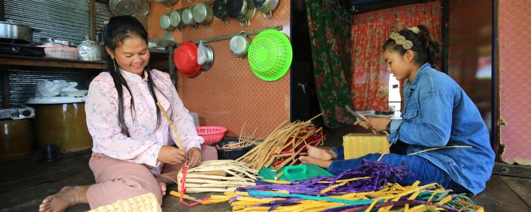 Roth Chhay (left) while making hyacinth handbag. Photo: Oxfam