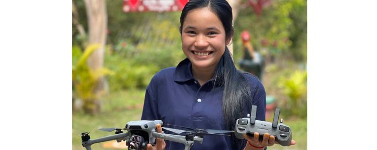 Soknan beams with pride as she holds the drone after a successful test flight. 