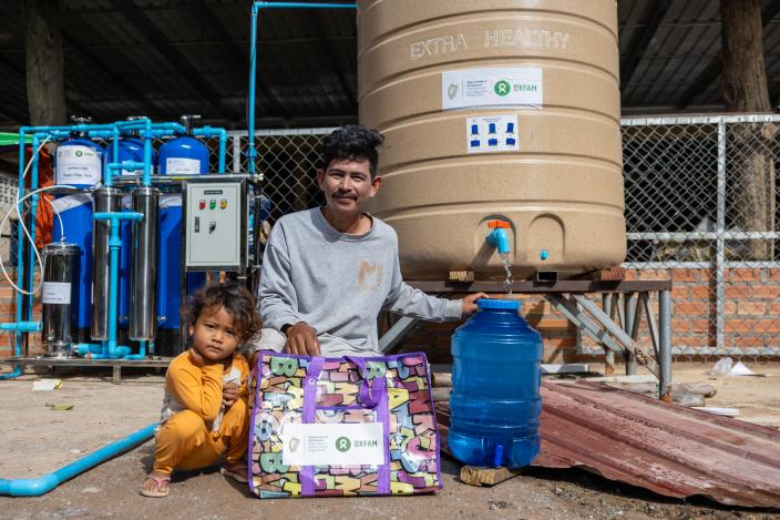 A displaced family collecting clean water from water tank provided by Oxfam