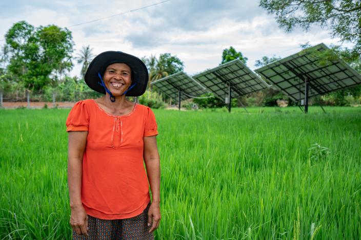Thea Bou standing in front of Solar Irrigation System in Kandieng district which is managed and operated by the local communities.