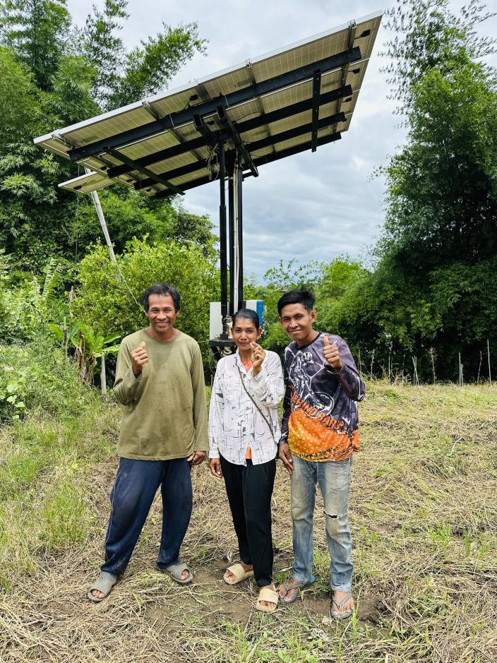 Theary and Lot (far right) in front of the movable solar-powered water pump. 
