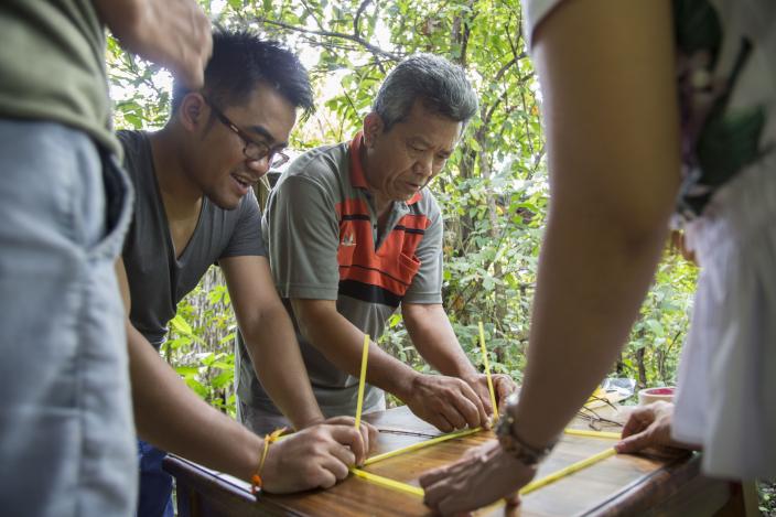 La (grey-orange shirt) works in a group, part of team building game, during annual program reflection in Tatai, Koh Kong, 2017. Photo: Seiha Tiep/Oxfam.