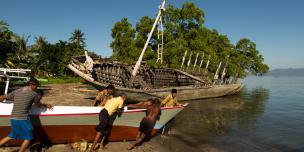 Sekelompok nelayan mendorong perahu baru untuk dicoba di pantai mengikuti petunjuk pemilik perahu Abdul Hamed (depan paling kanan), di Lewoleba, Kecamatan Nubatukan, Kabupaten Lembata, Provinsi Nusa Tenggara Timur, Indonesia. Credit: Rodrigo Ordonez/Oxfam.