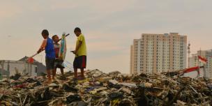 Anak-anak bermain di dekat sungai di satu wilayah dimana warga setempat baru saja digusur untuk pembangunan baru, dekat dengan komplek apartemen mewah di Jakarta Utara, Indonesia. Photo: Tiara Audina/Antropologi UI