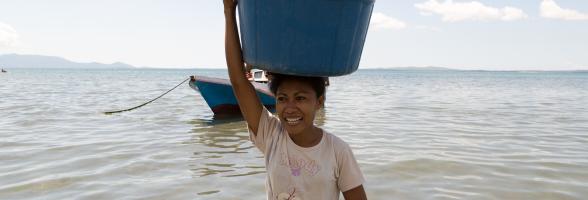 Aisha Selaka, membawa sebakul ikan diatas kepalanya setelah suaminya pulang melaut sejak malam sebelumnya. Aisha dan suaminya tinggal kampung Lewoleba, Nubatukan, Kabupaten Lembata, Provinsi Nusa Tenggara Timur, Indonesia. Credit: Rodrigo Ordonez/Oxfam