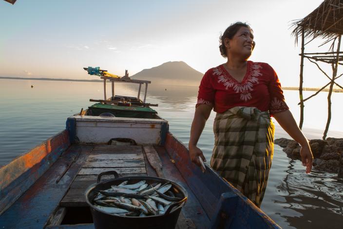 Istri nelayan di Nusa Tenggara Timur menyamabut suami pulang dari laut dengan sekeranjang ikan tangkapan. Credit foto: Rodrigo Ordonez/Oxfam