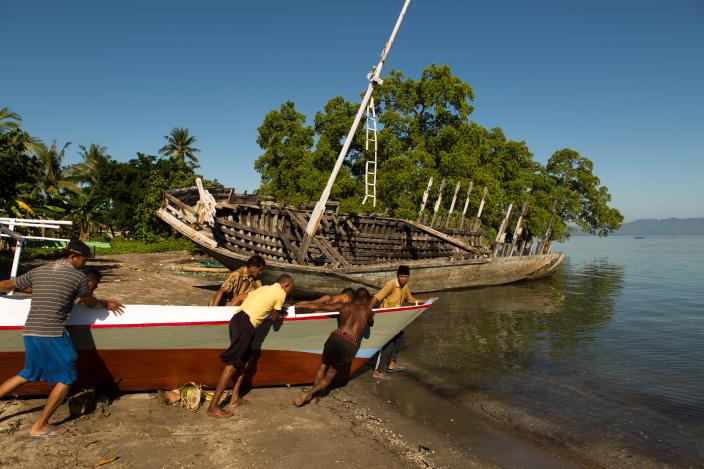Sekelompok nelayan mendorong perahu baru untuk dicoba di pantai mengikuti petunjuk pemilik perahu Abdul Hamed (depan paling kanan), di Lewoleba, Kecamatan Nubatukan, Kabupaten Lembata, Provinsi Nusa Tenggara Timur, Indonesia. Credit: Rodrigo Ordonez/Oxfam.