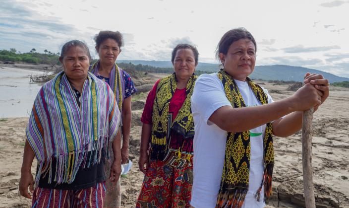 Guardians of their community. (left to right) Marice Nabuasa, Marica Ola, Marcelina Kause, and Femi Nautani stand near the river that often floods their village. Their women’s group is active in disaster management.