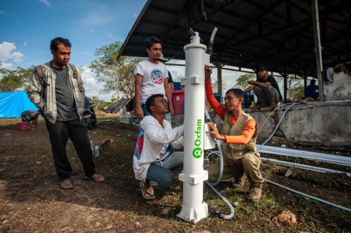 Palu, Indonesia: Sofian Adly (38) dari mitra Oxfam Pusat Kajian Perlindungan Anak (PKPA), memasang filter air hidran bersama dengan para sukarelawan di luar kota Palu (Kredit: Hariandi Hafid/OxfamAUS).