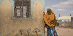 A woman uses her water credit, which is stored in a small, plastic token, to buy water from a Water ATM in Hadado, Kenya. Photo Credit: Katie Nelson