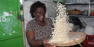 Small scale trader in Kibera market in Nairobi cleaning maize grains for sale in her small kiosk. Photo Credit: Benson Guantai