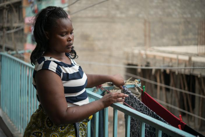 Domestic worker Elizabeth Wayua, 31, hangs clothes on the balcony outside her employer's house in Pipeline, Embakasi, Nairobi, Kenya. Photo Credit: Allan Gichigi