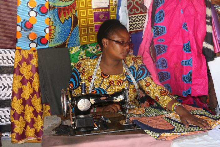 Peris sewing an african dress for a customer.